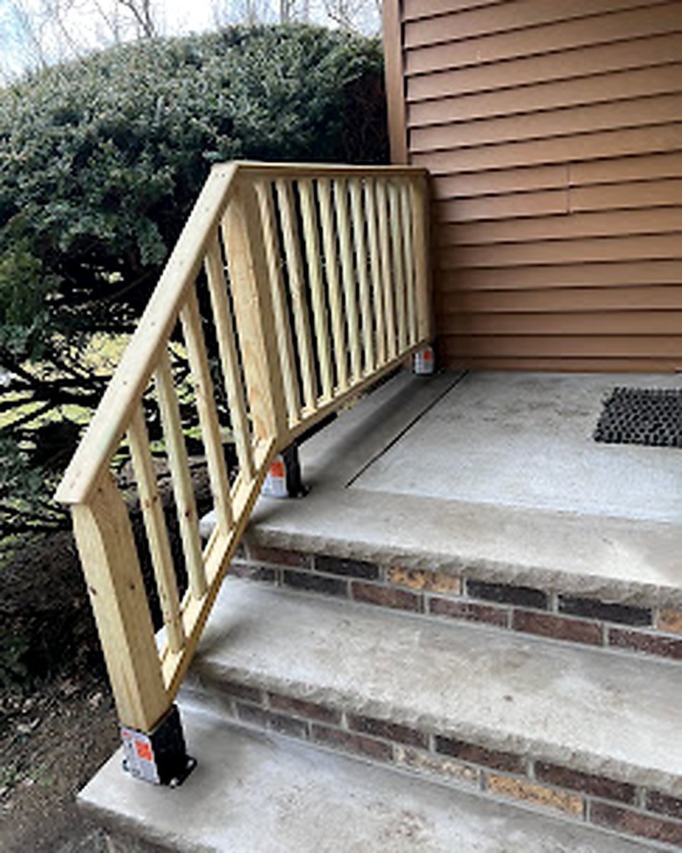 New wood deck railing on concrete porch entry