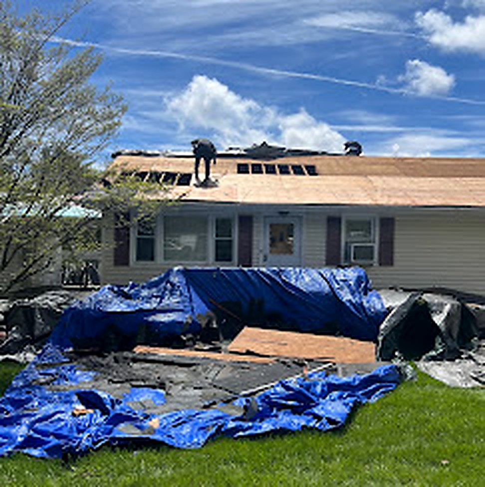 Emergency storm tarping on a damaged residential roof
