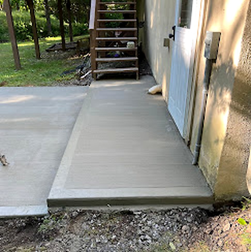 Newly poured concrete pad next to garage door